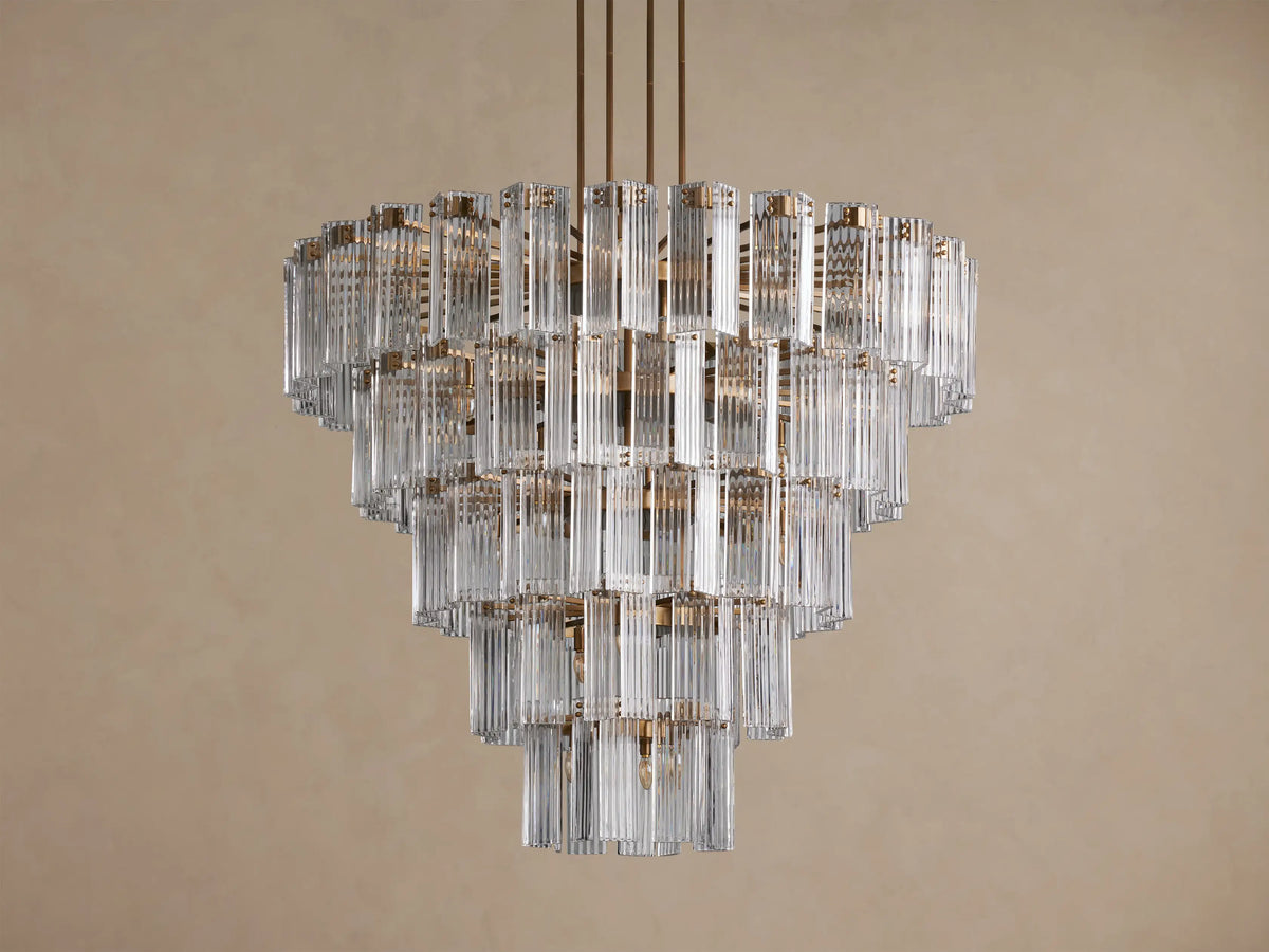 Delsie Round Chandelier: Tiered design with numerous clear vertical glass rods, burnished brass frame, brightly lit.