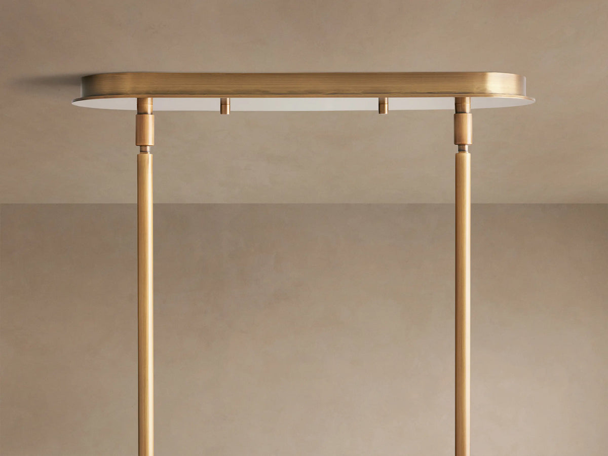 Close-up of Remming Linear Chandelier, featuring horizontal white milk glass cylinder held by burnished brass bands & pipe.