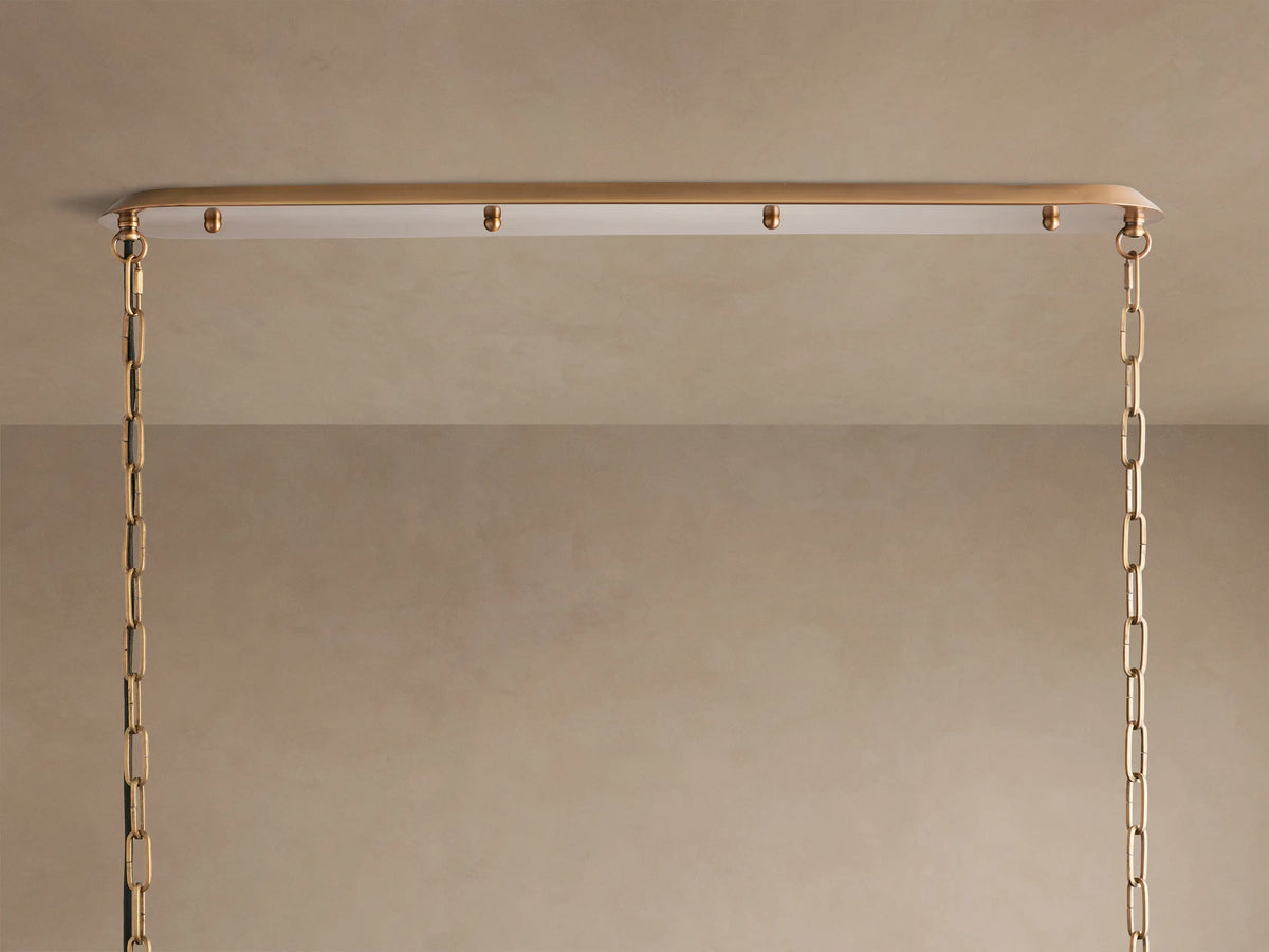 Shelton Linear Chandelier: White fabric shade with burnished brass frame and suspension rods, viewed from a low angle.