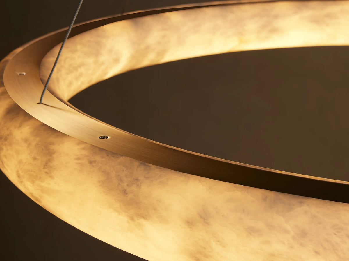 Halima Halo Chandelier made of translucent Spanish alabaster stone, emits warm light, showing intricate natural patterns.