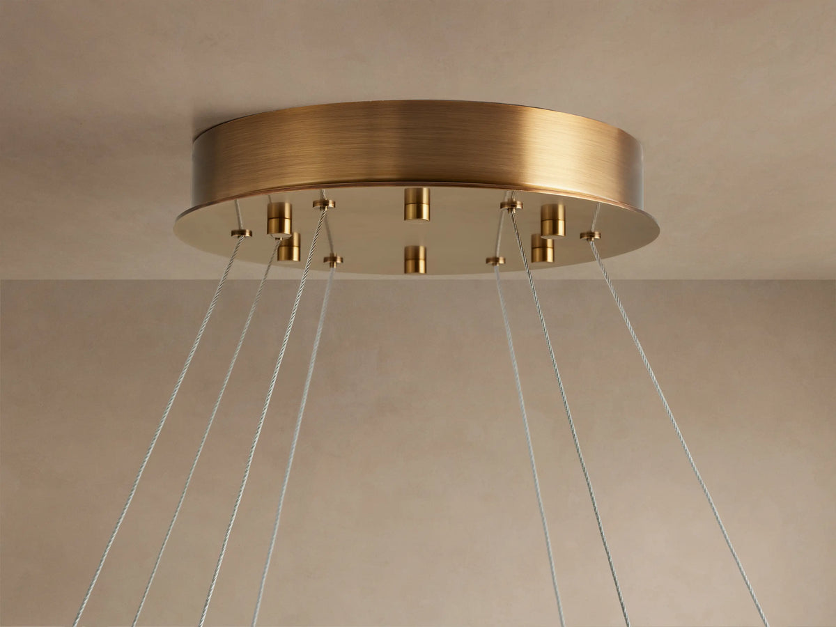 Front view of the white Halima Halo Chandelier, a large alabaster stone ring suspended by thin wires from above.