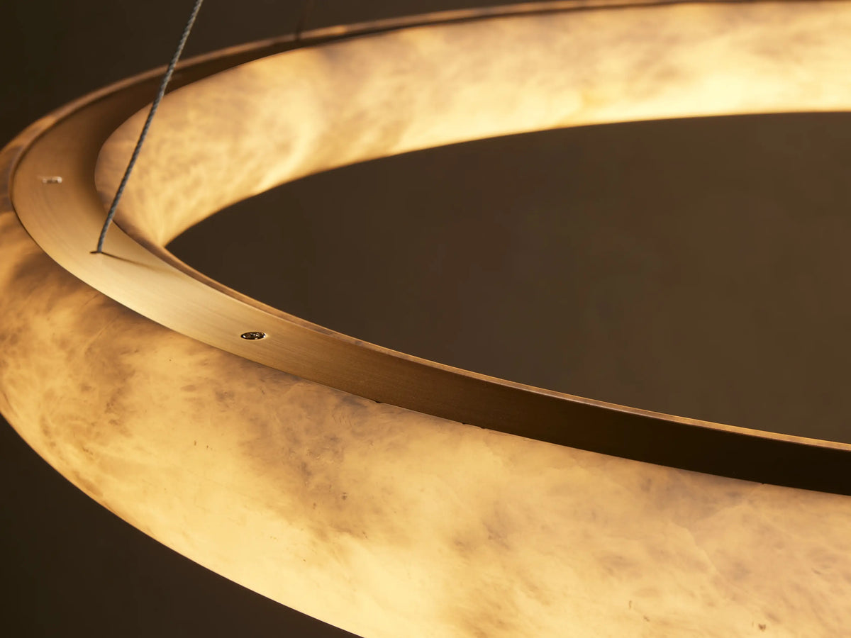 Close-up of the illuminated Halima Halo Chandelier, featuring the translucent Spanish alabaster with natural cream and grey veining.