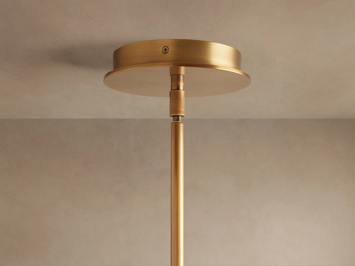 Lyla Single Pendant: Close-up of glowing white marbled hand-blown glass shade attached to a brushed brass fixture.