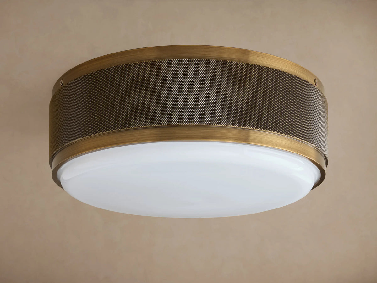 Ceiling light fixture with a dark bronze finish and perforated metal drum shade; glowing white glass diffuser underneath.