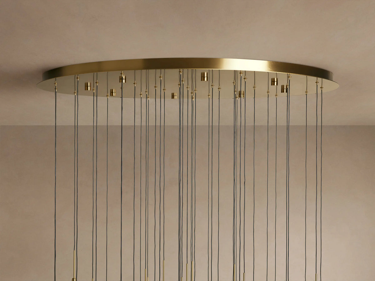 Solitaire Round Chandelier with brass finish, thin black cords hanging from a circular base mounted on the ceiling.