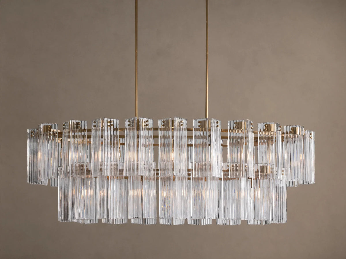 Delsie Oval Tiered Chandelier with burnished brass frame, two tiers of clear fluted glass rods, and visible bulbs.