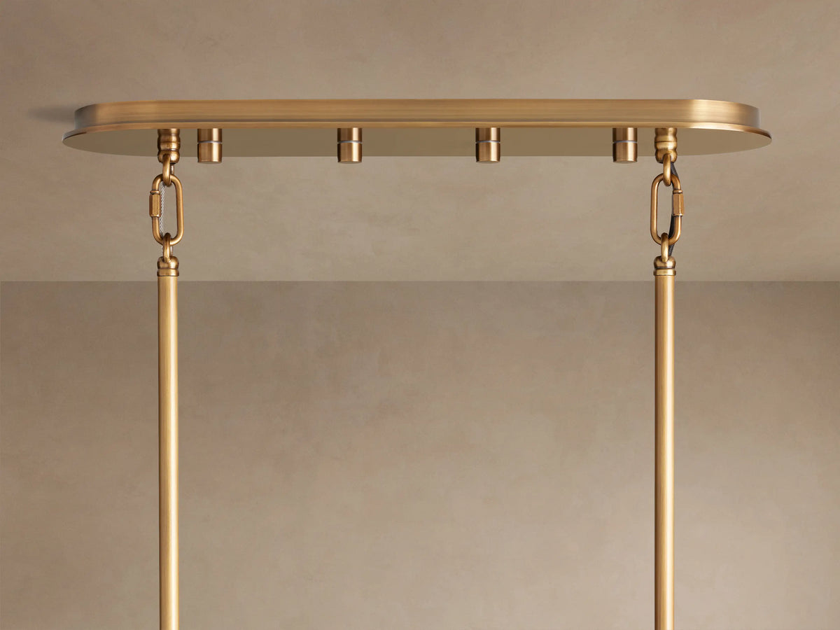 Close-up of Delsie Tiered Chandelier: clear fluted glass rods in staggered tiers, glowing warmly with burnished brass accents.