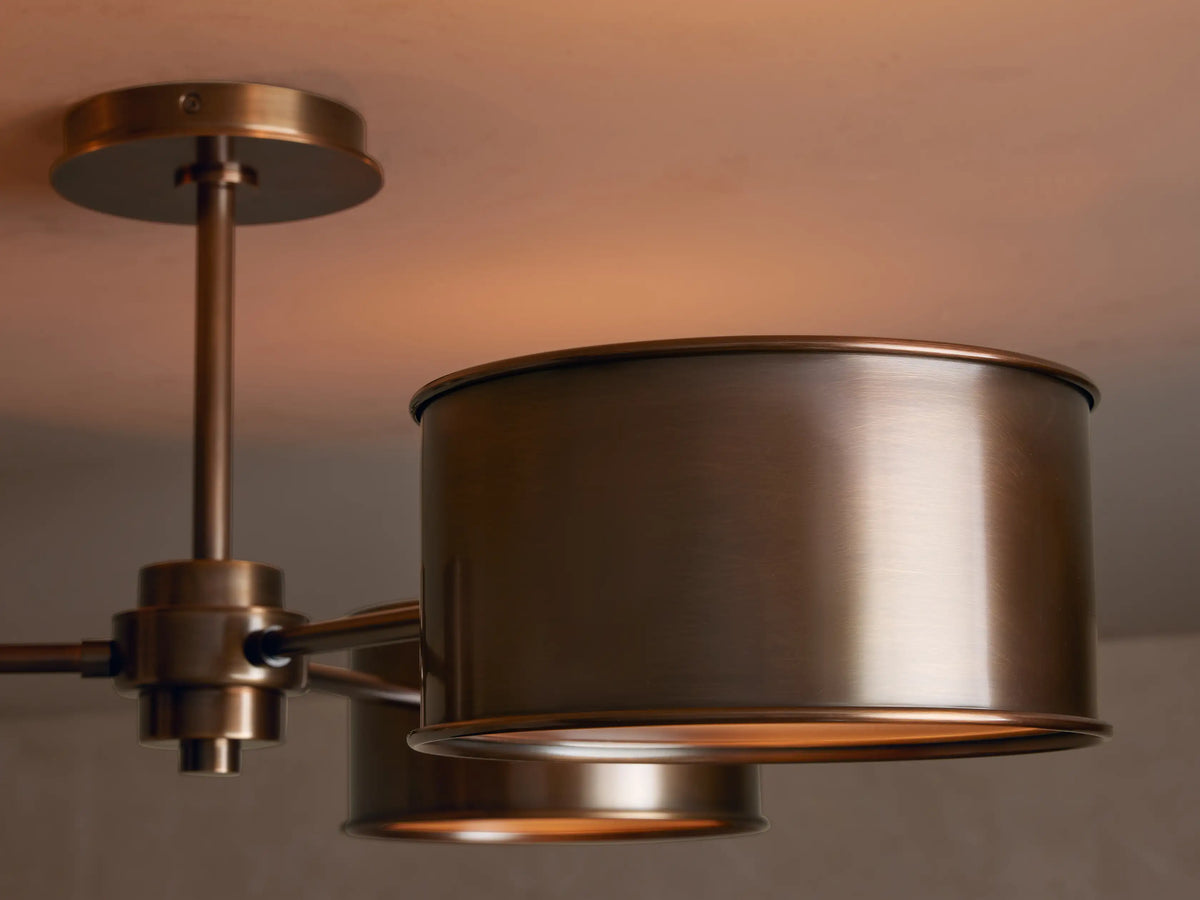 Daphne Metal Flush Mount ceiling light with three cylindrical warm bronze metal shades, mounted flush against a light ceiling.