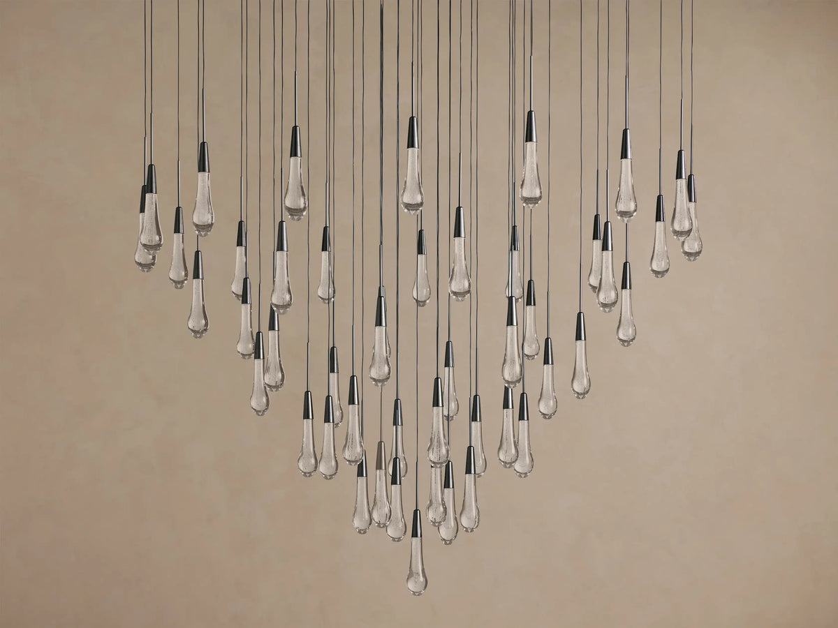 Soltaire Round Chandelier with multiple clear, textured, teardrop glass bulbs, dark metallic caps, suspended at varying lengths.