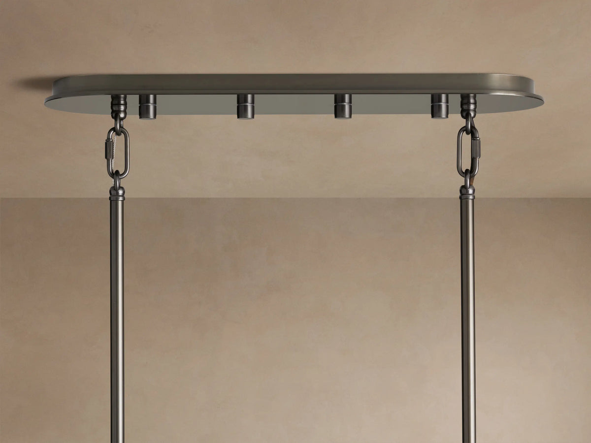 Close-up of Delsie Oval Tiered Chandelier with clear fluted glass rods, dark metal frame, and warm light glowing.