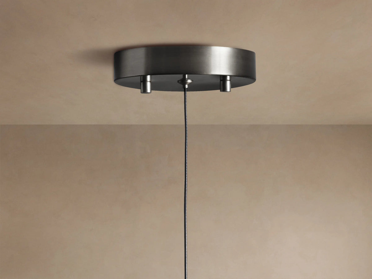 Soltaire Pendant: clear, teardrop-shaped glass with internal bubbles, dark metallic top, and a warm glowing LED at its base.