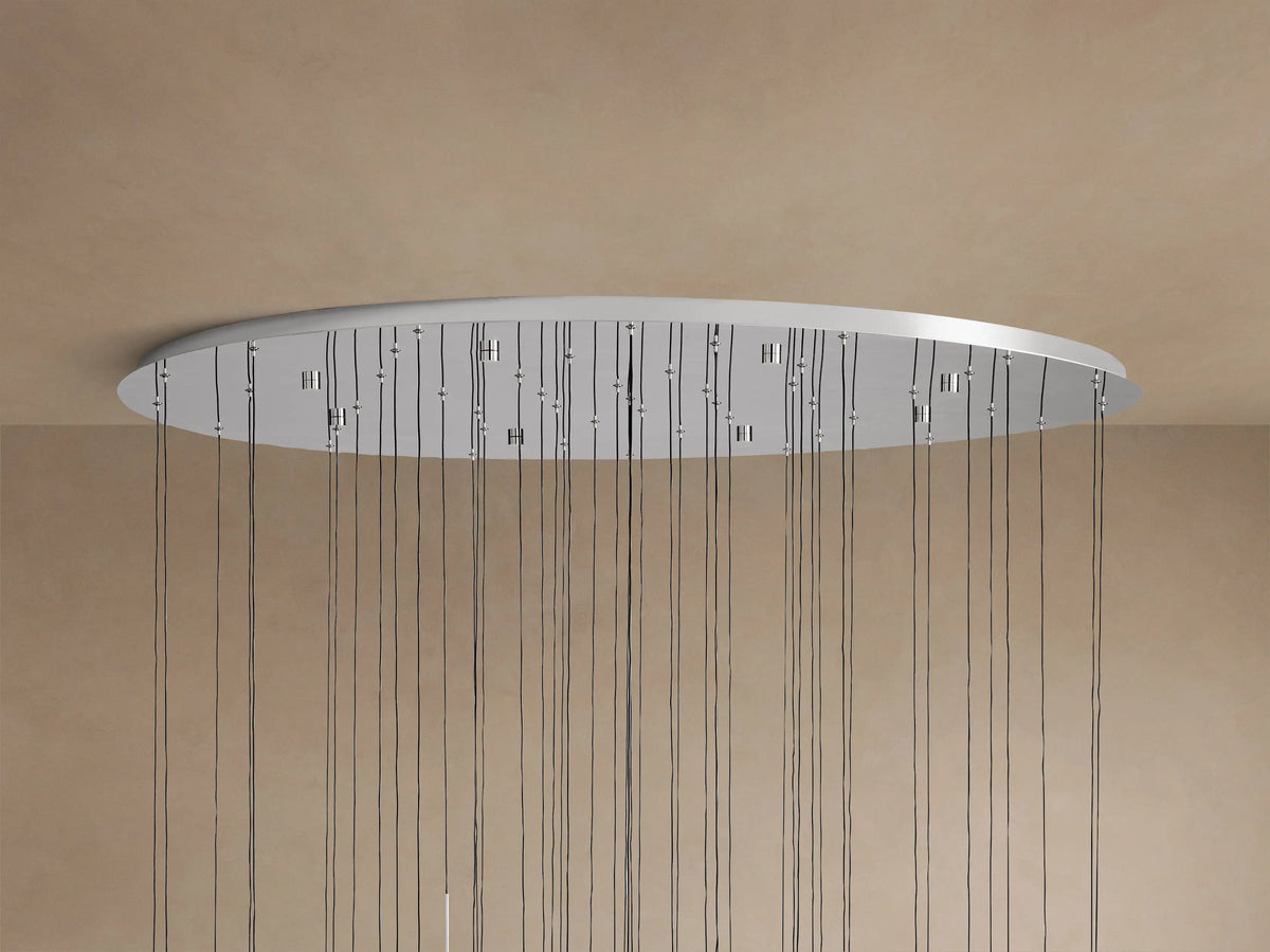 Soltaire Round Chandelier. Close-up of clear glass teardrop pendants with internal bubbles and polished nickel caps, illuminated from within.