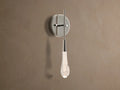 Soltaire Sconce with a shiny nickel backplate, featuring a glowing, clear tear-drop glass light fixture with internal bubbles.