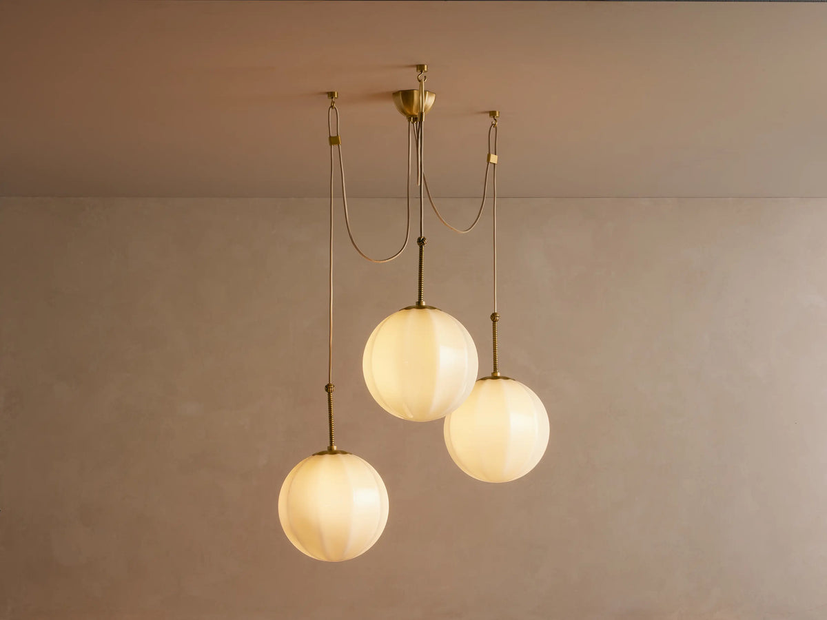 Agnes Chandelier antique brass ceiling canopy with fluted design, showing three cream fabric cords descending from it.