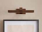 Horizontal Corinth Picture Light Sconce in a dark bronze finish, emitting warm LED light onto a framed artwork below.