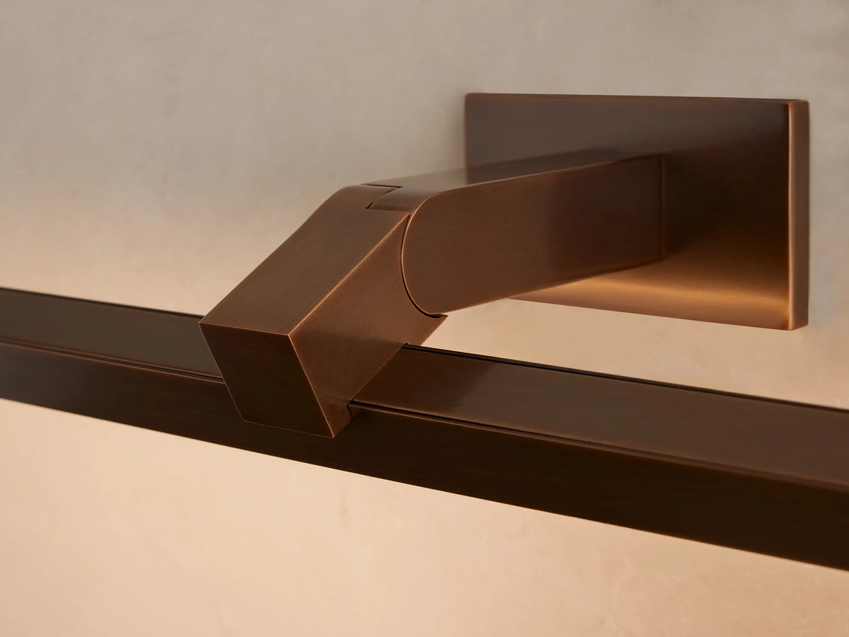Bronze Corinth Picture Light Sconce, horizontally mounted above a framed abstract painting on a light neutral wall.