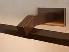 Bronze Corinth Picture Light Sconce, horizontally mounted above a framed abstract painting on a light neutral wall.