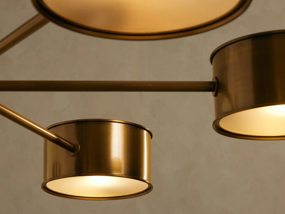 Daphne Metal Round Chandelier in antique brass, with a central rod and six arms holding cylindrical metal shades facing downwards.