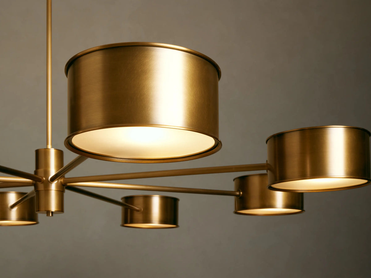 Daphne Metal Round Chandelier in a lustrous gold finish, with eight radiating arms holding cylindrical metal shades.