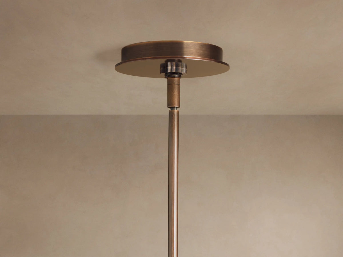Daphne Metal Round Chandelier, close-up of warm bronze finish, cylindrical metal shades casting a soft, warm glow.
