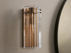 Delsie Sconce: Rectangular wall-mounted light with fluted clear glass and burnished brass frame, casting warm glow.