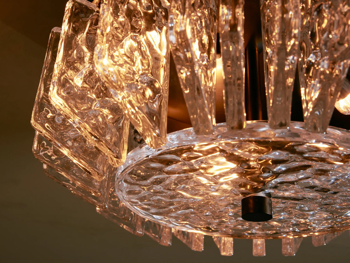 Liliana Flush Mount, a dark bronze-finished ceiling light with clear, chunky textural glass panels arranged in a circle, mounted on a light ceiling.