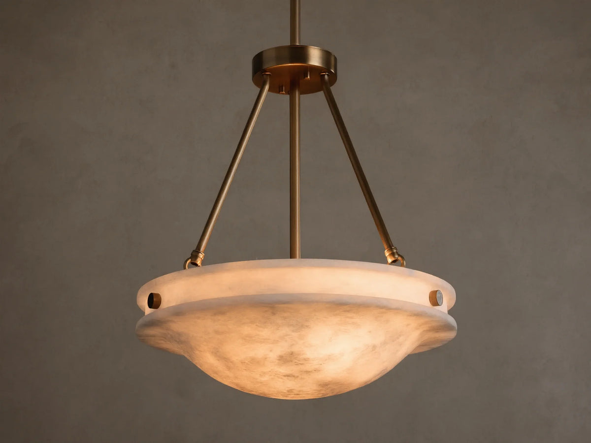 Front view of the Edith Pendant with a brass finish and a glowing, marbled alabaster stone shade.