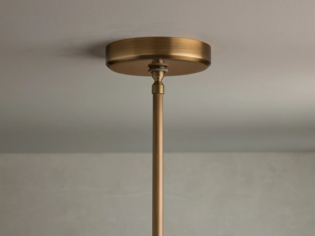 Close-up of the brass finish cylindrical ceiling canopy and hanging rod for the Edith Pendant.