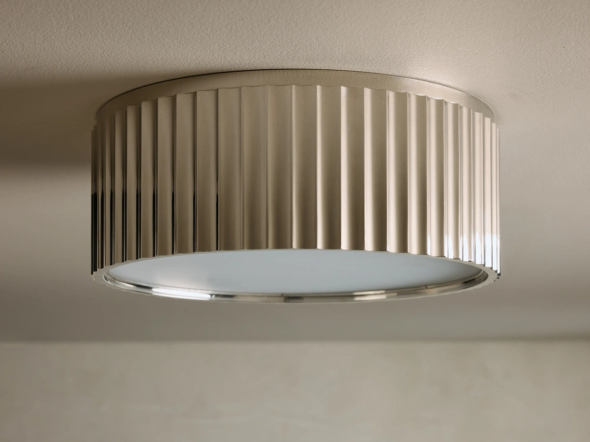 Close-up of the glowing Brushed Nickel Fluted Flush Mount Light, showing vertical flutes and warm light emission.