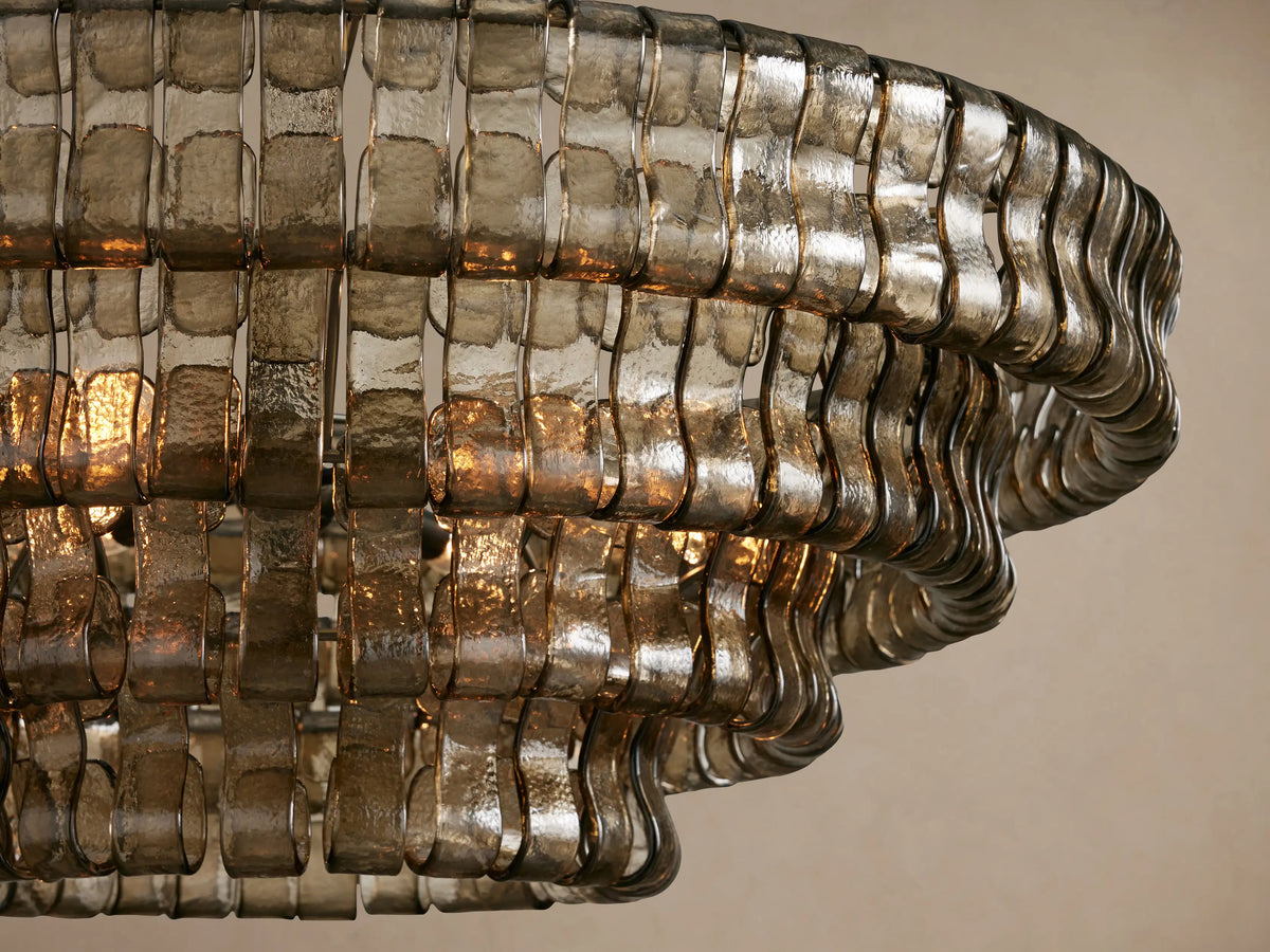 Ghiaccio Round Chandelier, close-up. Textured smoky grey curved glass segments glow with warm light from within.
