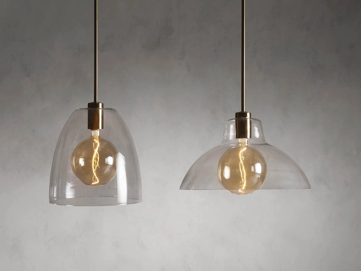 Bauer Dome Pendant's brass ceiling mount with chain and black cord. Circular base secured to white ceiling, highlighting modern design.