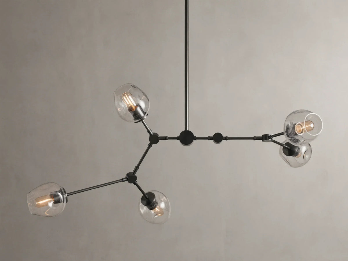 Noella Bronze Chandelier with five arms, clear glass bulb covers, and a sleek bronze finish against a light gray background.