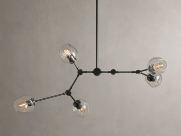 Noella Bronze Chandelier with five arms, clear glass bulb covers, and a sleek bronze finish against a light gray background.