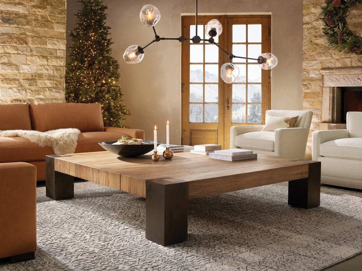 Circular bronze ceiling mount with a single black rod extending downward, attached to a neutral-colored ceiling.