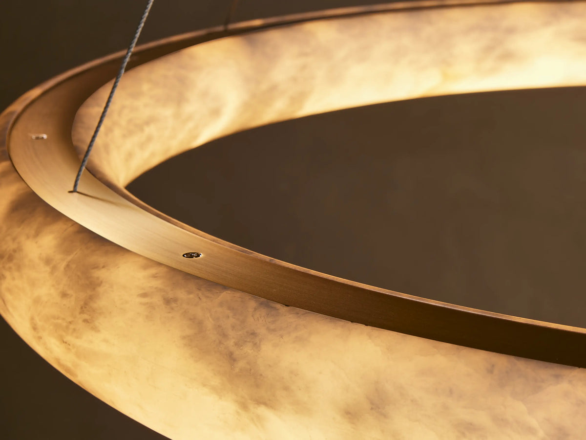 Close-up of a warm glowing ring light fixture with a translucent, marbled alabaster-like shade.