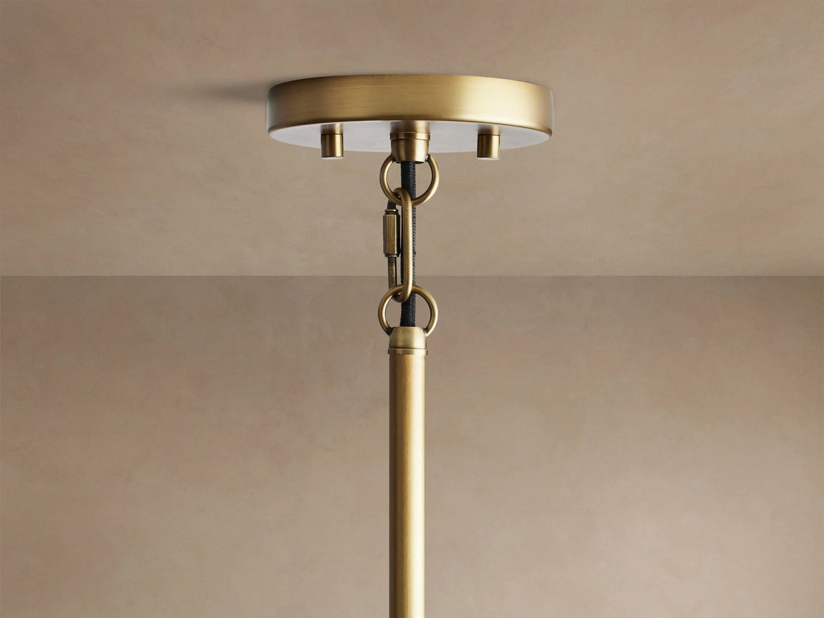 Andreas Pendant, a close-up of its brushed bronze metalwork and ribbed clear glass shade with a glowing filament bulb.