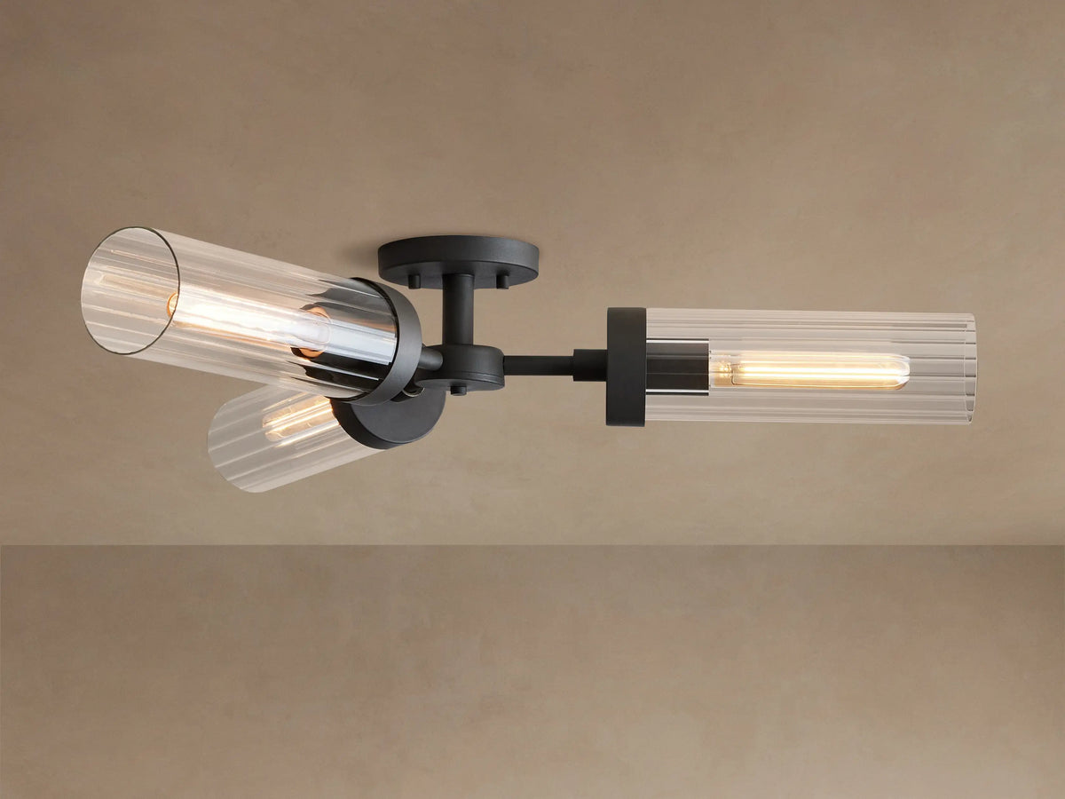 Andreas Flush Mount light with black base & arms, three ribbed clear glass shades, and warm glowing bulbs on a ceiling.
