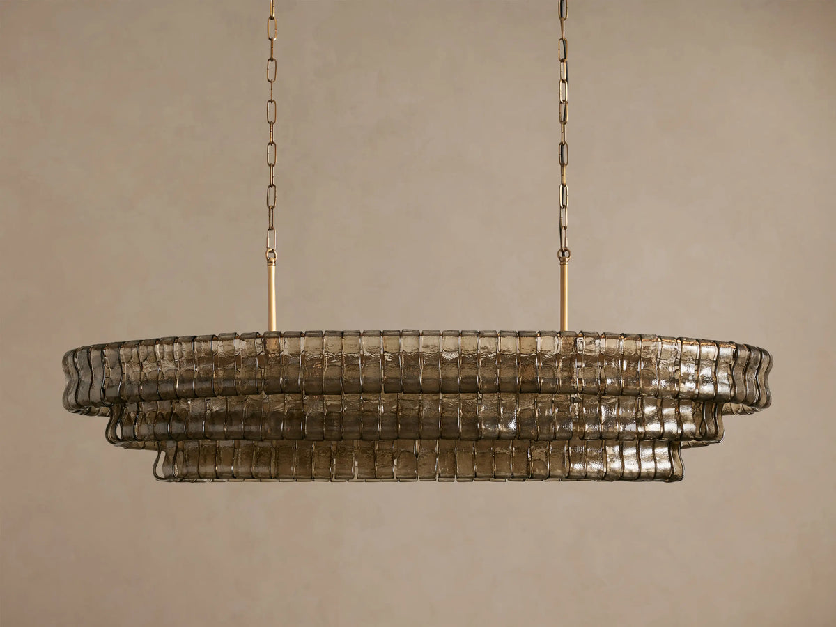 Ghiaccio Oval Chandelier: tiered oval, smoky textured glass, illuminated from within, suspended by gold chains.