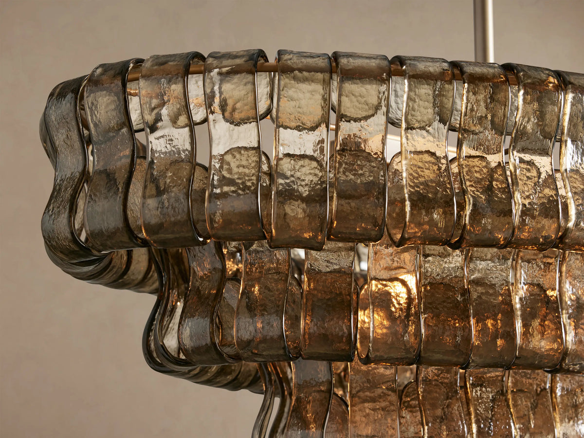 Ghiaccio Oval Chandelier with multi-tiered smoky bronze textured curved glass panels, suspended horizontally by two brass chains.