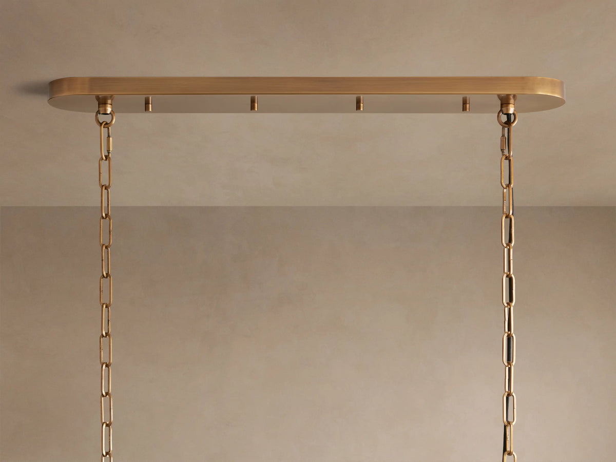 Smoky, wavy, textured glass panels of the Ghiaccio Oval Chandelier, reflecting warm light from within.