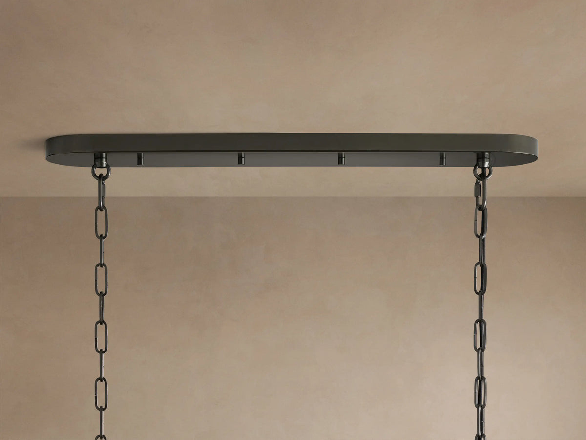 Close-up of Ghiaccio Oval Chandelier, showing wavy, textured dark glass panels with warm light glowing from within.