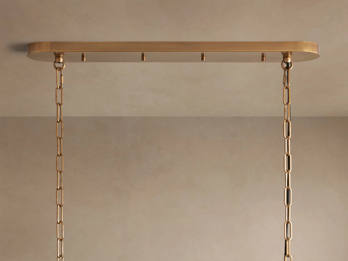 Close-up of Ghiaccio Oval Chandelier with layered, wavy, textured clear glass bands, glowing warmly from within.