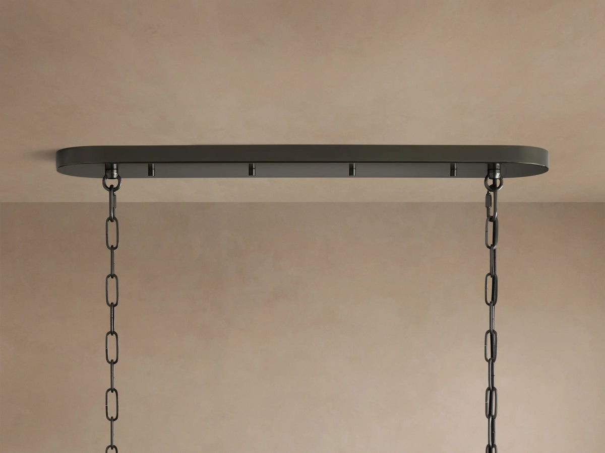 Close-up of a glowing Ghiaccio Oval Chandelier, featuring multiple tiers of curved, textured, smoky glass pieces.