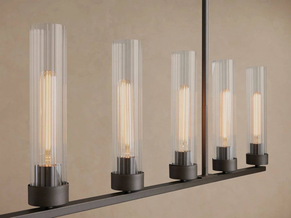Andreas 8-light linear chandelier with a black frame and clear ribbed glass shades, suspended by chains against a light wall.