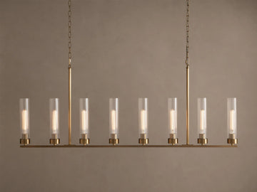 Andreas Linear Chandelier: 8-light, brass-finished, horizontal bar with clear cylindrical glass shades, exposing filament bulbs, hanging.