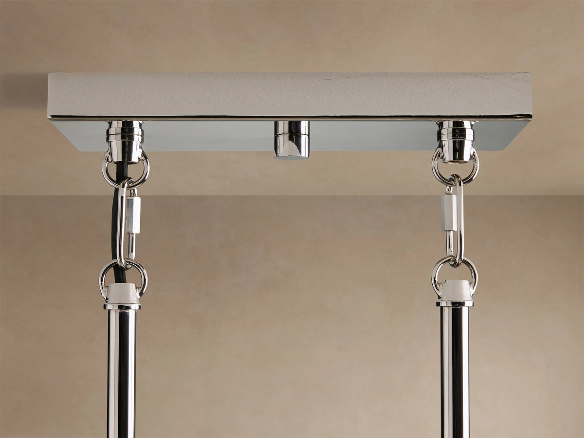 Close-up of Andreas Linear Chandelier: polished chrome linear frame supporting multiple clear ribbed glass cylindrical shades with bulbs.