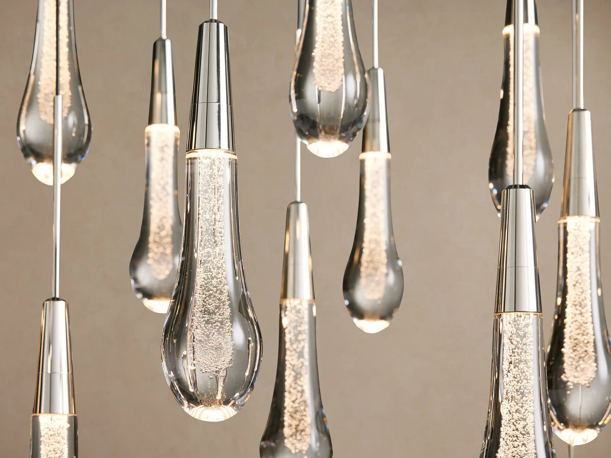 Soltaire Linear Chandelier: clear glass teardrop pendants with silver-finished caps hanging from thin wires in multiple rows.