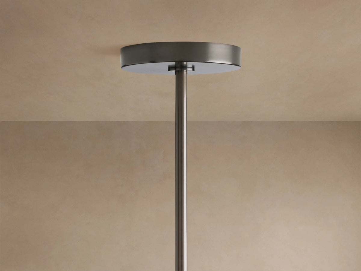 Top of Mandoza Chandelier with dark metallic round ceiling canopy and slender suspension rod against a beige ceiling.
