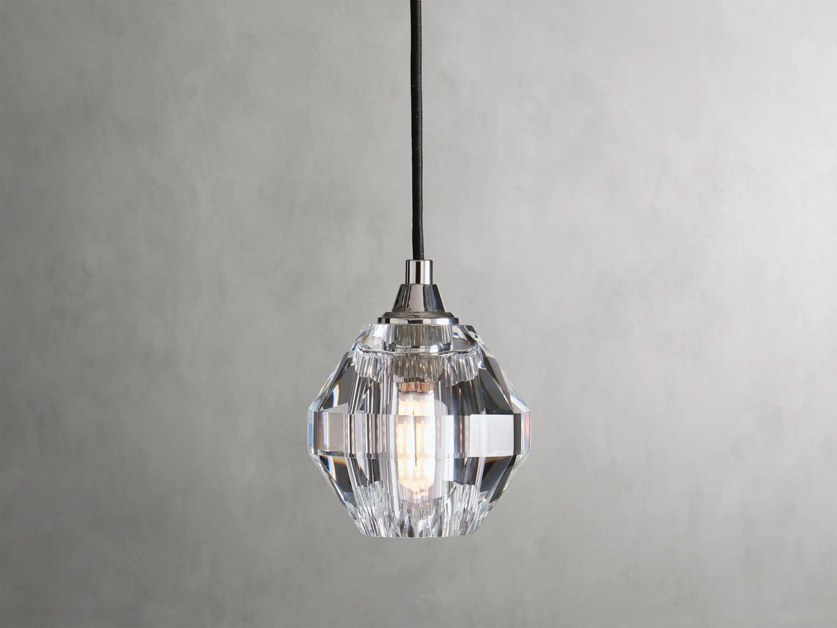 Amoroso Pendant with faceted crystal shade hanging from a black cord, showcasing a dimmable LED bulb inside.