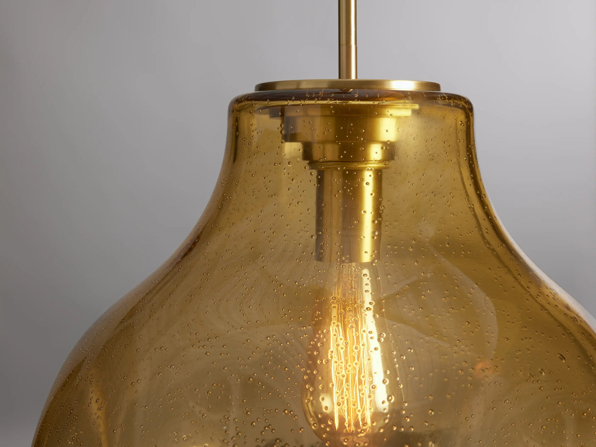 Organic 16" Pendant with amber-colored mouth-blown glass and steel, teardrop shape, suspended with a visible bulb inside.